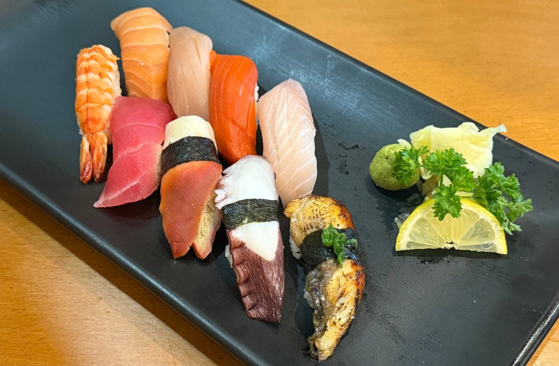 Assorted nigiri on a black plate