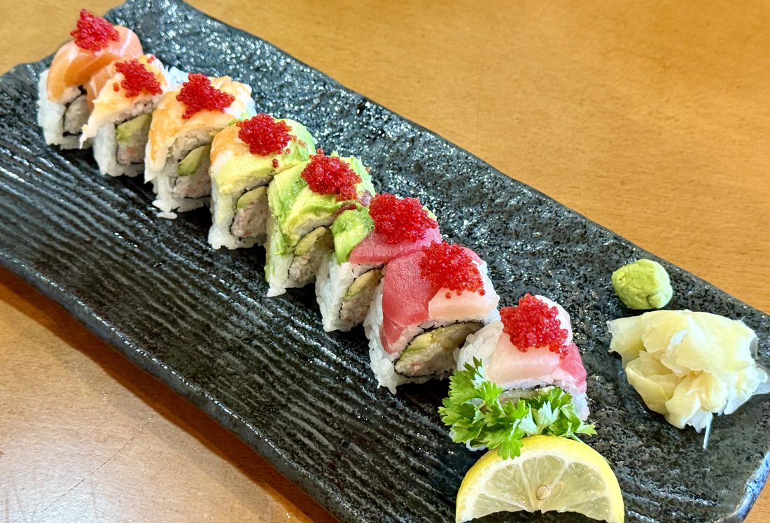 Rainbow roll topped with assorted fish, avocado and tobiko